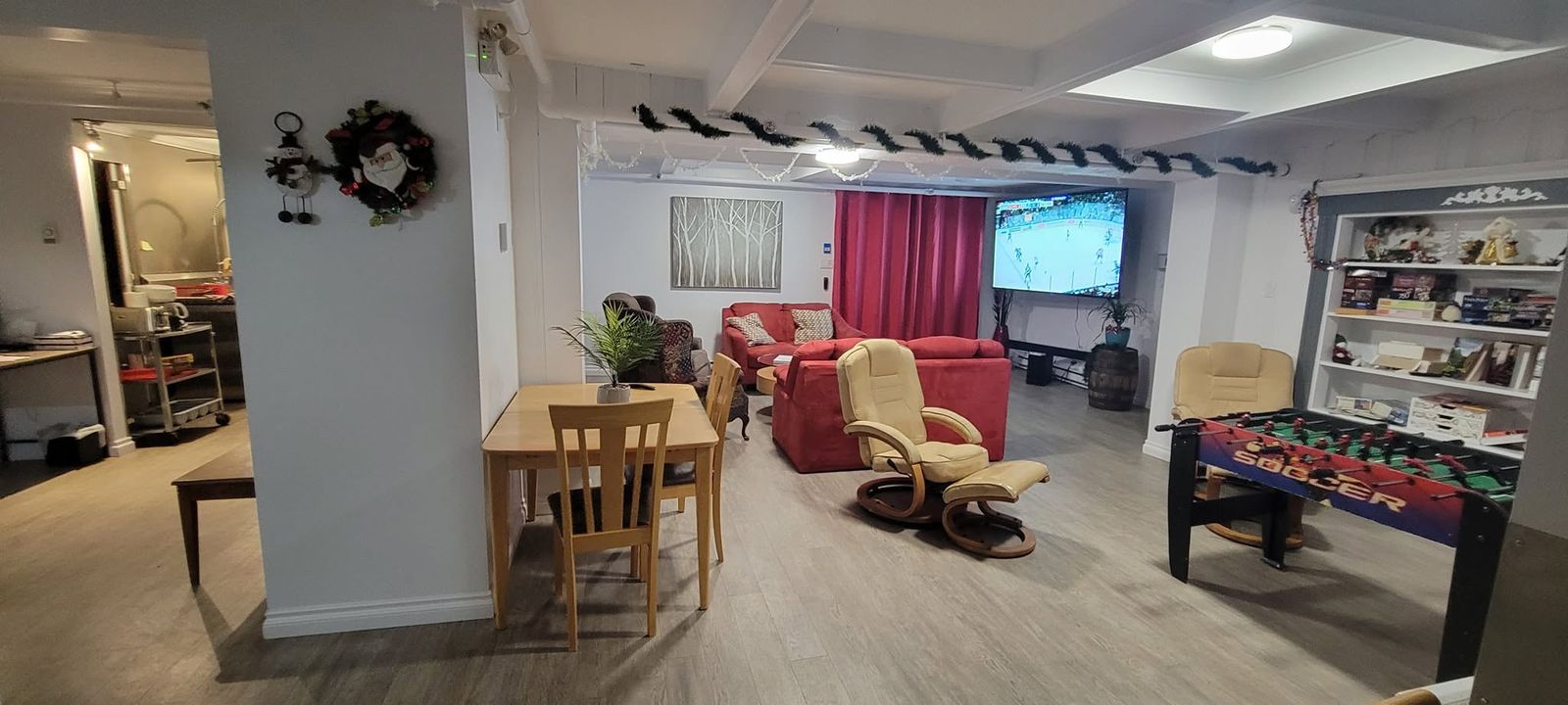 Salon commun avec grand écran et baby-foot, Auberge Résidence Nordique